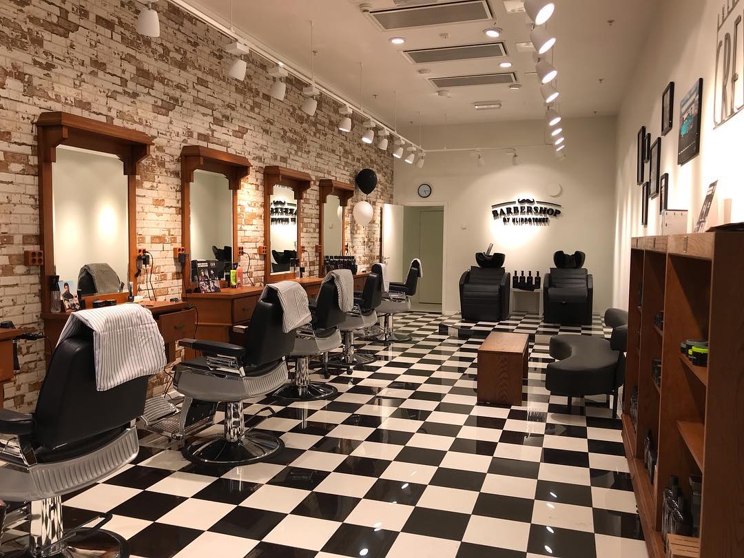 Klippoteket Sollentunas salong med barberarstolar, exponerad tegelvägg och schackrutigt golv